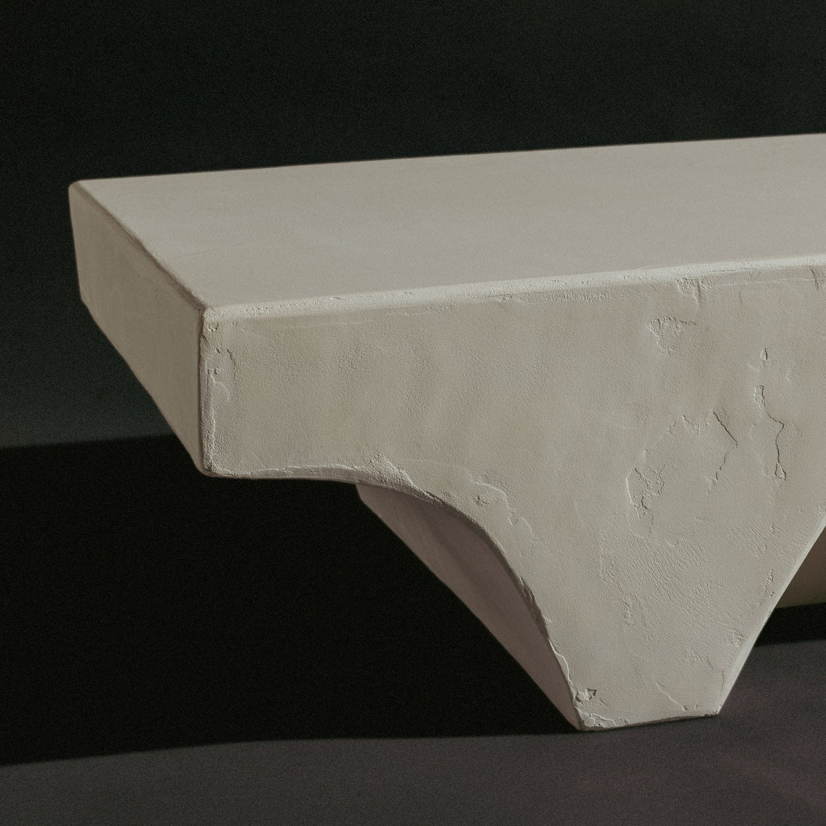 Minimal sculptural bench with rough natural stone texture.