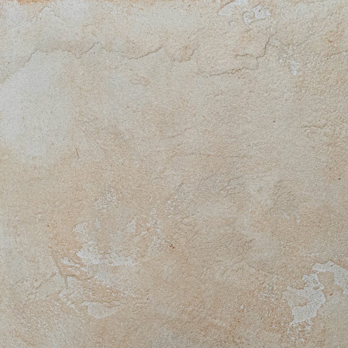 A close-up of a textured beige stone stool, finished with micro-cement, limestone