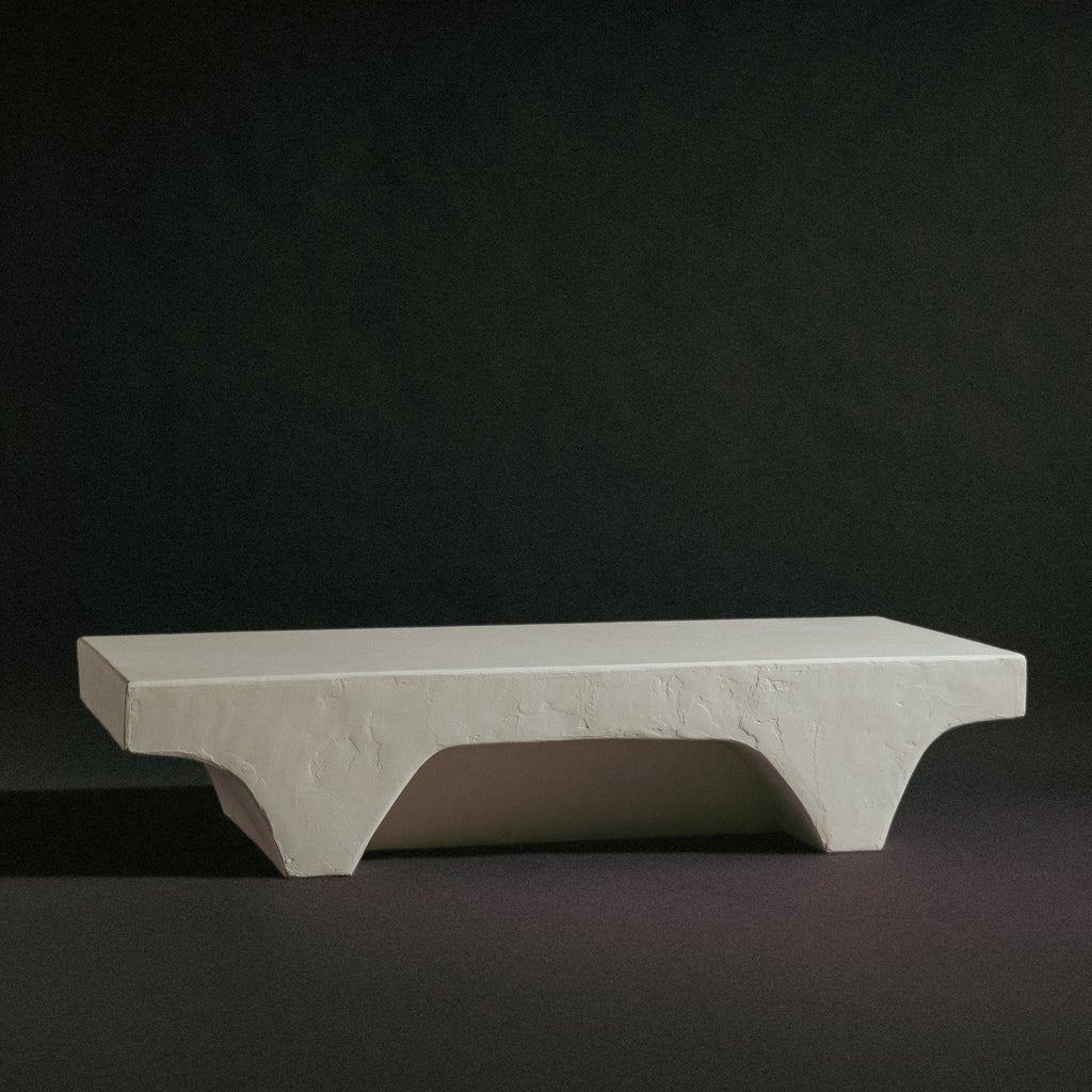 A minimal concrete bench or side table with a thick rectangular body. 
